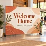 Welcome Home slider backdrop in cream and terracotta standing in a bright church lobby